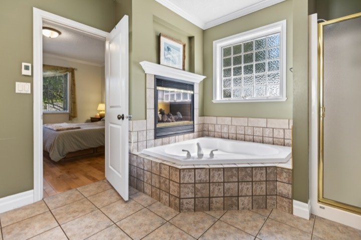 Bathroom with a corner tub and fireplace