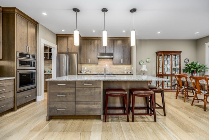 Kitchen with a large island, pendant lights and hardwood floors