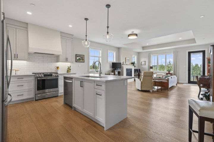Bright white kitchen with an island, open to the living area