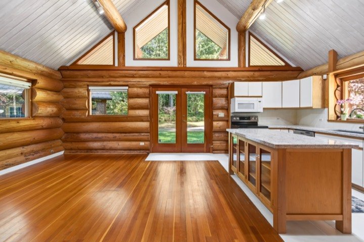 Log home kitchen beneath a vaulted wood ceiling
