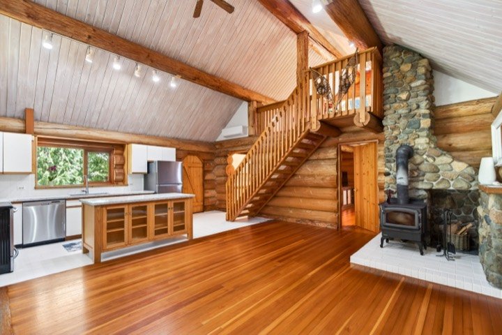 Log home with a wood stove and open staircase