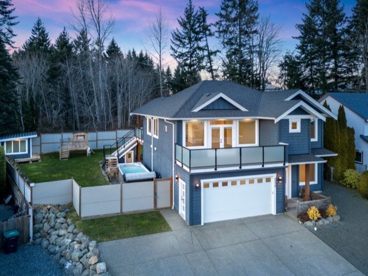 Twilight exterior of a modern home with a glass balcony